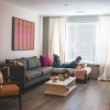 living room with someone laying on a couch reading a book